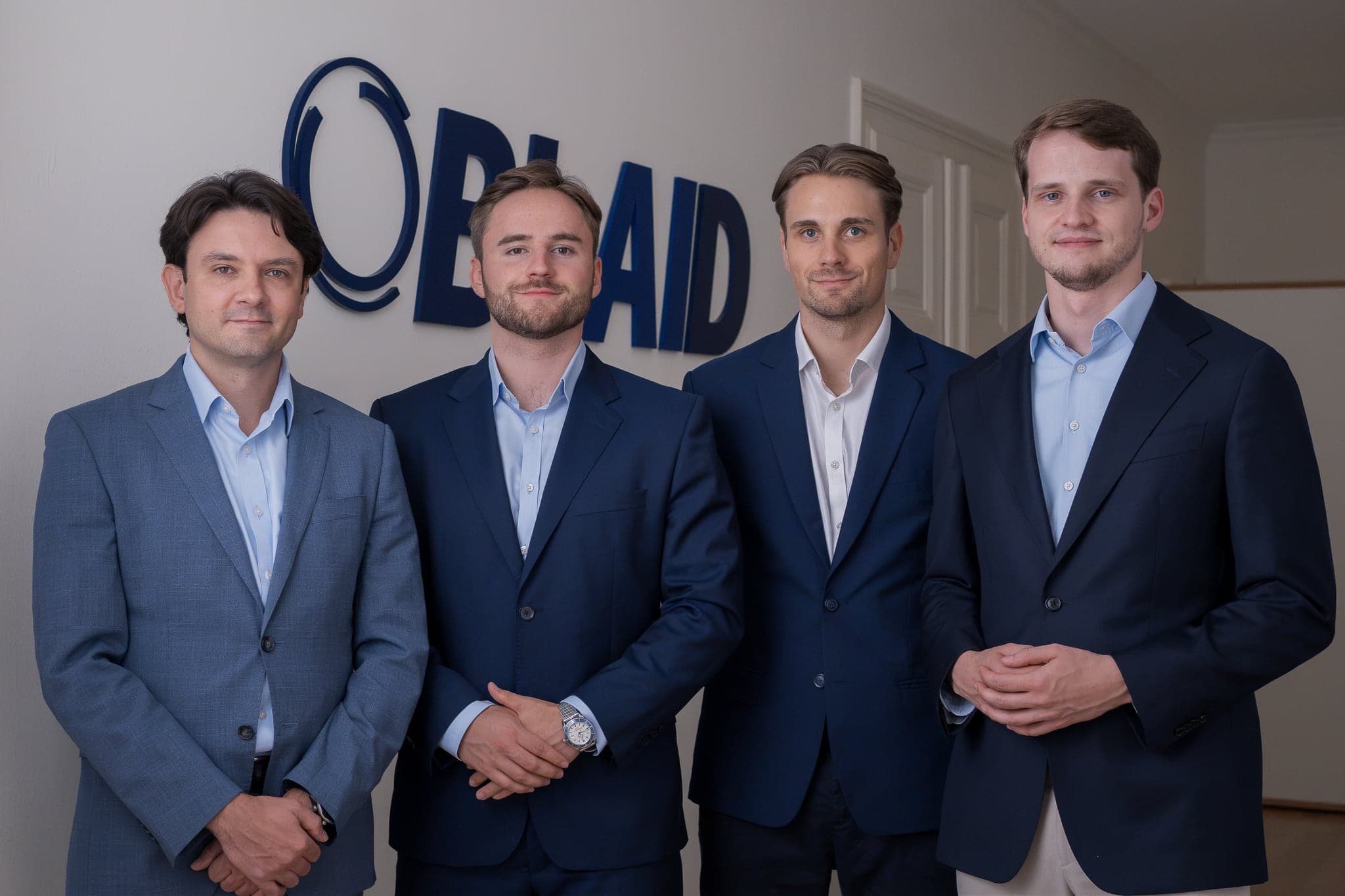 Vier Mitglieder des BLAID-Teams vor dem Firmenlogo